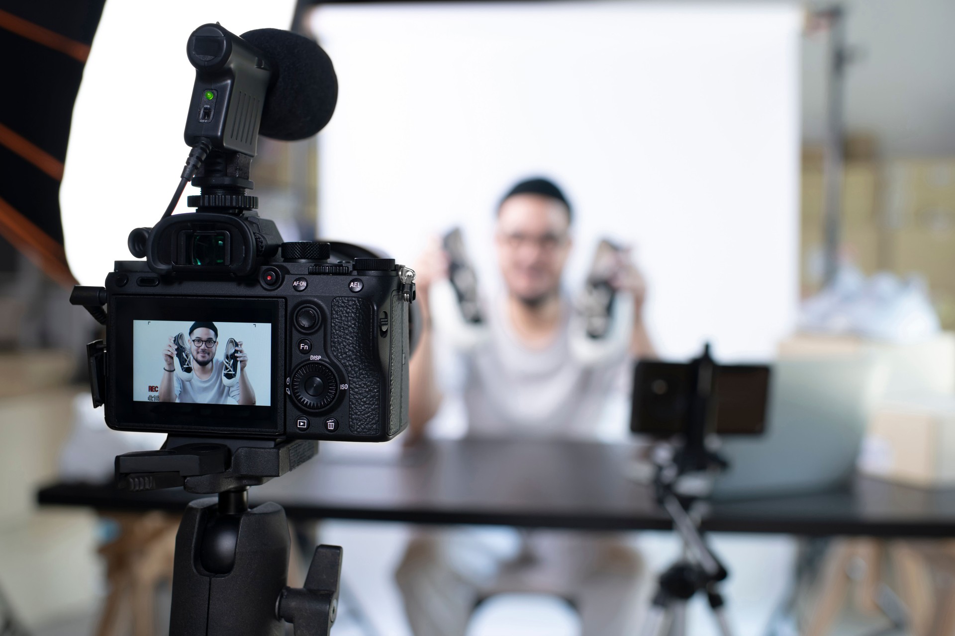 Asian man blogger or vlogger looking at camera reviewing product.